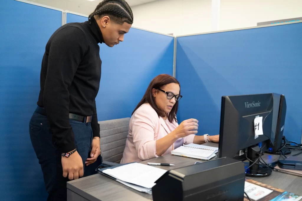 JBS employees looking at a computer to learn reporting FinCEN requirements