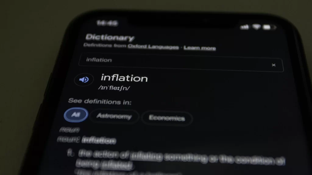 a phone showing the definition of inflation - a macroeconomic indicator