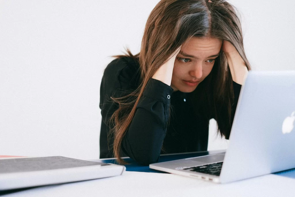 A woman on her laptop, stressed about filing a tax extension